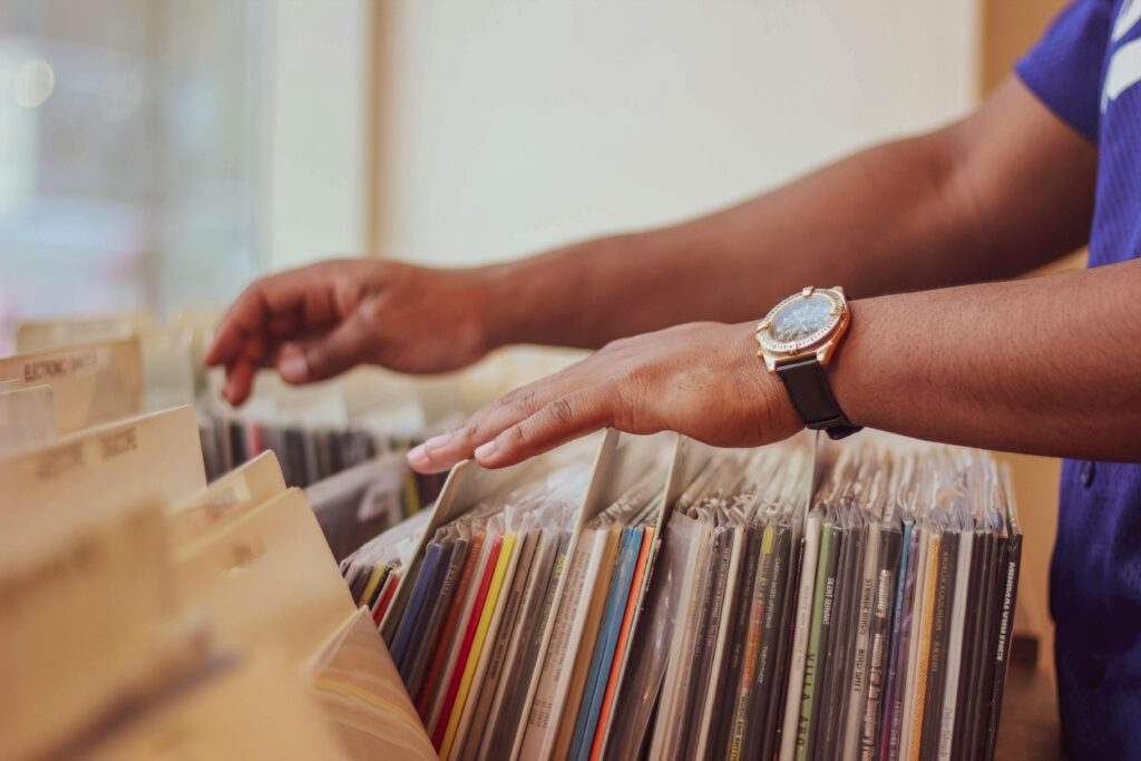 Close-up of hands browsing vinyl records in a store, showcasing a classic vintage collection.